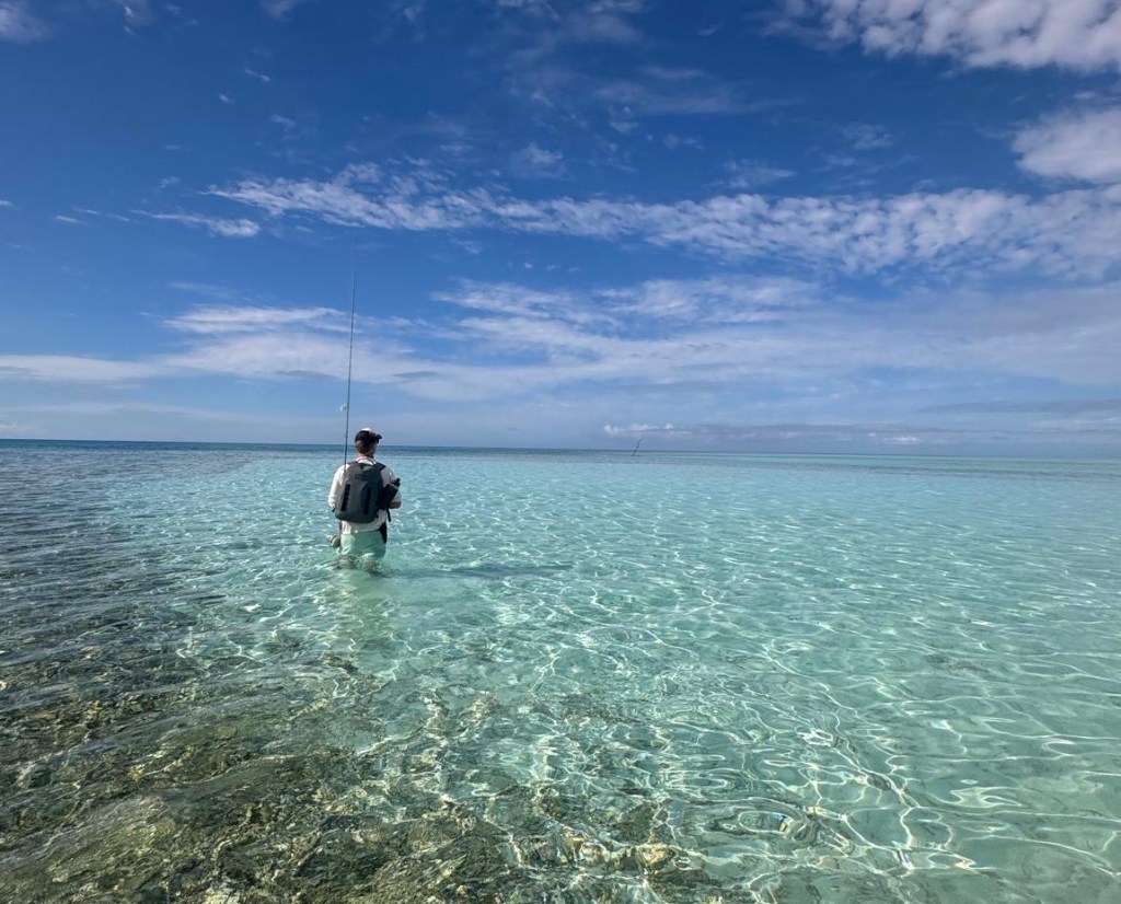 Fly fishing destination with angler casting in remote clear water